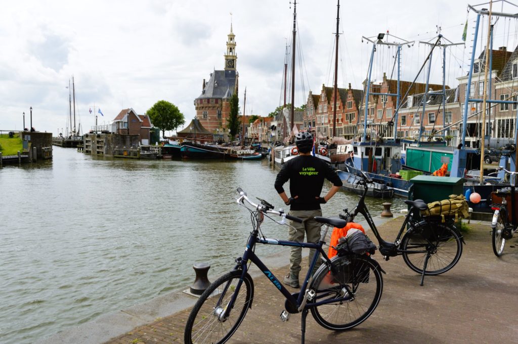 cycliste de dos face à un port.