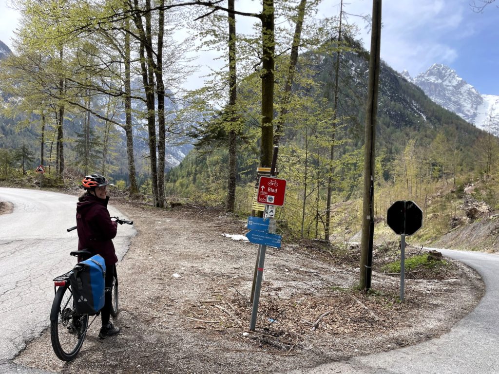 col en forêt avec cycliste à côté de panneau de signalisation